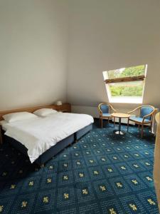 a bedroom with a bed and a table and chairs at Hotel Am Schlosspark , Wiesbaden in Wiesbaden