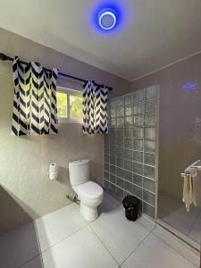 La salle de bains est pourvue de toilettes, d'une fenêtre et d'une douche. dans l'établissement FOND B'OFFAY LODGE, à Victoria
