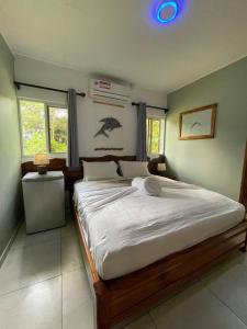 a bedroom with a large bed with white sheets at FOND B'OFFAY LODGE in Victoria