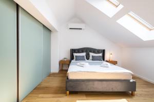 a bedroom with a bed in a loft with skylights at Luxury Central Loft by Carmen Sylva in Bucharest