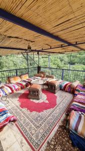 ein Wohnzimmer mit Sofas und einem Teppich in der Unterkunft auberge gite de jeunesse les Cascades in Setti Fatma