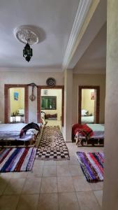 Großes Zimmer mit 2 Betten und 2 Teppichen in der Unterkunft auberge gite de jeunesse les Cascades in Setti Fatma