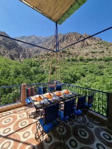 einen Tisch und Stühle auf einem Balkon mit Bergblick in der Unterkunft auberge gite de jeunesse les Cascades in Setti Fatma