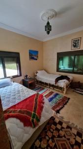 1 Schlafzimmer mit 2 Betten und einem Teppich in der Unterkunft auberge gite de jeunesse les Cascades in Setti Fatma