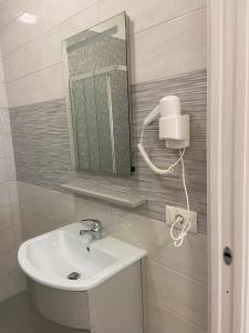 ein Bad mit einem Waschbecken und einem Spiegel in der Unterkunft Palazzo dei Baroni in San Bartolomeo in Galdo
