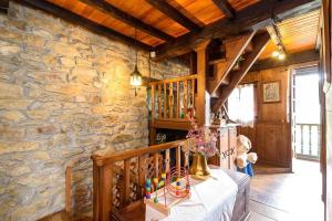 Habitación con una mesa en una pared de piedra. en La Casa Rectoral de El Tozu, en Caso