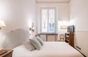 una camera da letto con un grande letto bianco e una finestra di San Lorenzo 21 Apartment a Genova