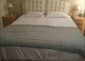 1 cama grande con manta gris y 2 mesitas de noche en Hillside View, en Redditch
