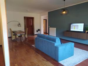 a living room with a blue couch and a table at Anema Home in Serino
