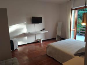 een slaapkamer met een bed en een tv aan de muur bij Anema Home in Serino