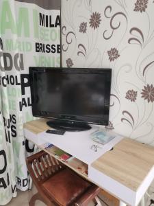 a desk with a computer monitor on top of it at Chambre privé avec salle de bains privative et dressing in Reugny