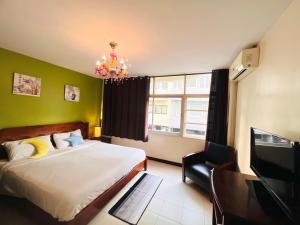 - une chambre avec un lit, une télévision et un lustre dans l'établissement Baan Nilawan Hua Hin Hotel, à Hua Hin
