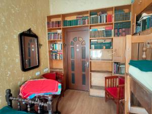 a room with a bed and a door with books at Guest House Irina Tbilisi in Tbilisi City