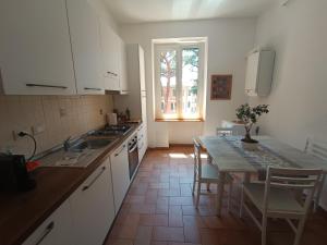 uma cozinha com armários brancos, uma mesa e uma janela em Casa Vacanze Garbatella em Roma