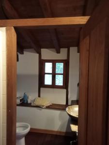 ein Bad mit einem Waschbecken, einem WC und einem Fenster in der Unterkunft Casa Cahecho in Cahecho