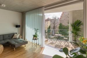 a living room with a couch and a balcony at Carlotta Apartments in Berlin