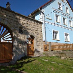 - un grand bâtiment blanc avec une porte en bois dans l'établissement Statek Bílý Dvůr, à Machov