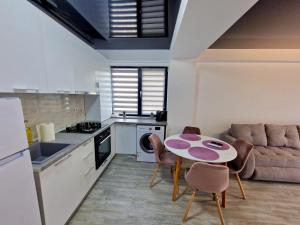 a kitchen with a table and chairs and a couch at CCD Apartments in Năvodari
