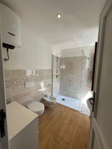 uma casa de banho com um chuveiro, um WC e um lavatório. em Ninfa Alghero em Alghero
