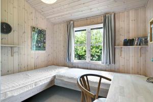 Kleines Zimmer mit einem Bett und einem Fenster in der Unterkunft Cozy Cottage In A Quiet Area Close To The Beach in Dannemare