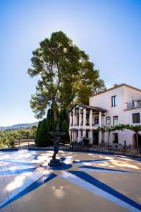 a statue in front of a building with a tree at Eco Hotel con encanto Masía la Mota B&B in Alcoy
