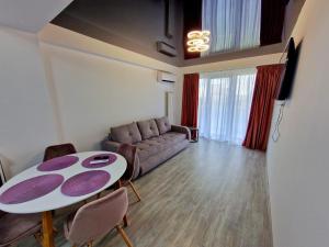 - un salon avec une table et un canapé dans l'établissement CCD Apartments, à Năvodari