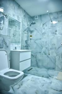 een badkamer met een toilet en een glazen douche bij Apartament 3 camere In centru in Râmnicu Vâlcea