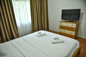 een slaapkamer met een bed met twee handdoeken erop bij Apartament 3 camere In centru in Râmnicu Vâlcea