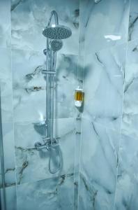een douche met een douchekop in de badkamer bij Apartament 3 camere In centru in Râmnicu Vâlcea