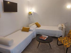 Habitación con 2 camas, mesa y TV. en Apartamentos San Salvador Parking Gratis, en Mérida