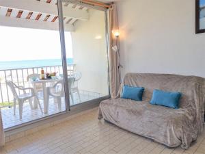 a living room with a couch and a balcony at Apartment Les Balcons de la Méditerranée-14 by Interhome in Narbonne-Plage