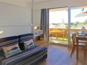 a bedroom with a bed and a table and a balcony at Apartment Arenes Pyrenees by Interhome in Canet-en-Roussillon