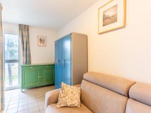 sala de estar con sofá y armario azul en Apartment Village Cheval Spa Résidences-3 by Interhome, en Lacanau-Océan