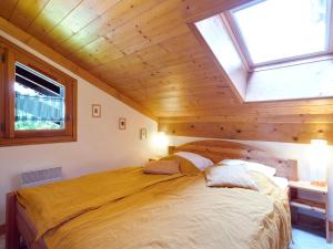 a bedroom with a large bed with a wooden ceiling at Apartment Le Tagre by Interhome in Mémontel
