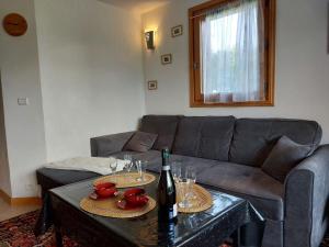 a living room with a couch and a table with wine glasses at Apartment Le Tagre by Interhome in Mémontel