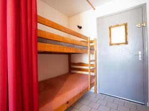 Habitación con 2 literas y cortina roja. en Apartment Le Florid-3 by Interhome, en Cap d'Agde