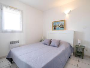 um quarto branco com uma cama e uma janela em Apartment La Palme d'Or-4 by Interhome em Cap d'Agde