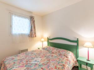1 dormitorio con 1 cama, 2 lámparas y ventana en Apartment Village Cheval Spa Résidences-3 by Interhome, en Lacanau-Océan