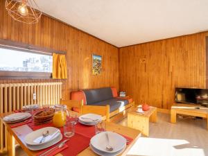 uma sala de estar com uma mesa e um sofá em Apartment Le Pramecou-3 by Interhome em Tignes