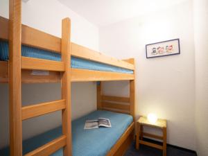 a bedroom with bunk beds with a table and a lamp at Apartment Pegase Phenix-53 by Interhome in Le Corbier