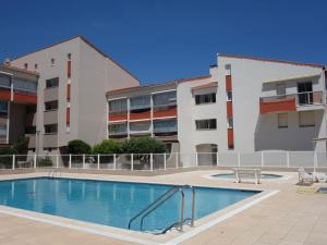 una piscina frente a dos edificios de apartamentos en Apartment Les Golfes Clairs by Interhome, en Plage dʼArgelès