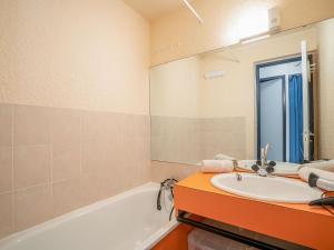 a bathroom with a sink and a tub at Apartment Pegase Phenix-53 by Interhome in Le Corbier