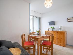 uma sala de estar com uma mesa e cadeiras e uma televisão em Apartment Le Beaupré-2 by Interhome em Canet-en-Roussillon