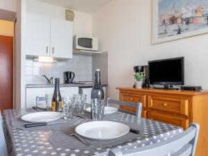 - une table à manger avec 2 bouteilles de vin dans l'établissement Apartment Le Beach-1 by Interhome, à Canet