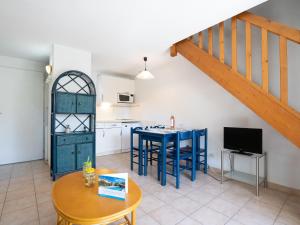 a kitchen with a blue table and a kitchen with a staircase at Holiday Home Les Lavandines 1-6 by Interhome in Cap d'Agde