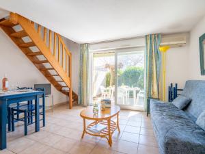 a living room with a blue couch and a table at Holiday Home Les Lavandines 1-6 by Interhome in Cap d'Agde