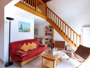 sala de estar con sofá rojo y escalera en Apartment le Martagon-1 by Interhome, en Saint-Gervais-les-Bains