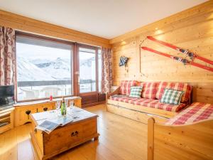 a living room with a couch and a large window at Apartment Le Bec Rouge-2 by Interhome in Tignes