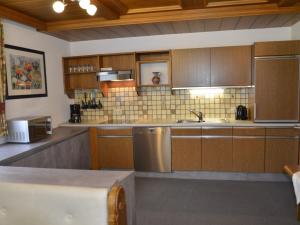 eine große Küche mit Holzschränken und einem Waschbecken in der Unterkunft Apartment Alpenrose - KPL185 by Interhome in Kappl