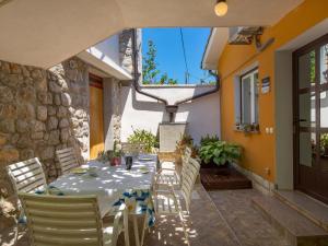 a patio with a table and chairs and a building at Apartment Sandalj-2 by Interhome in Kraj
